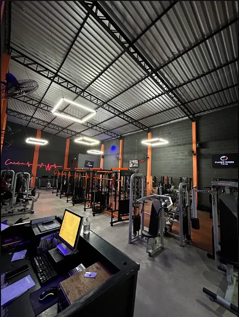 Ampla área de musculação iluminada na Fusion Fitness Maria Cândida